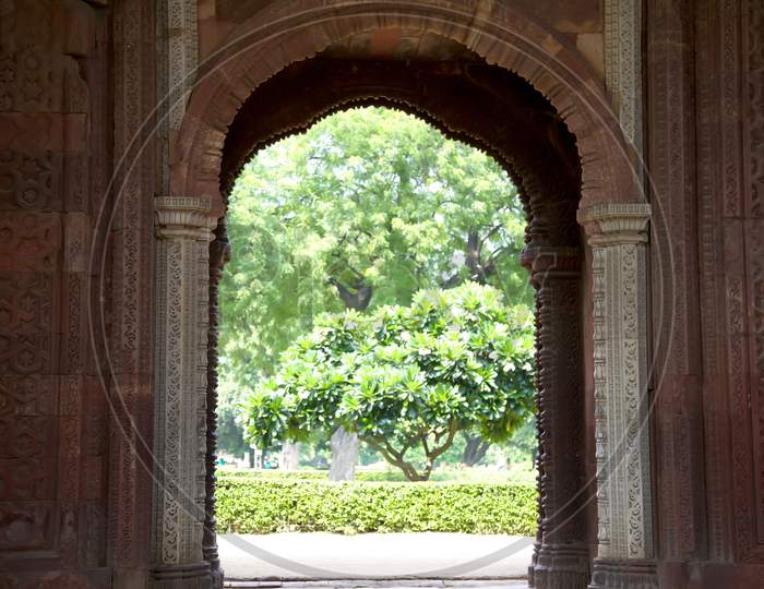 Looking Out From Inside Alai Darwaza, The Natural World Of Trees And Shrubs Is A Contrast To The Man-Made Gate. Qutub, Delhi, India