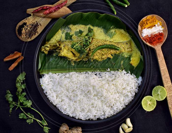Parsey fish with rice on a black plate and decorated with spices.