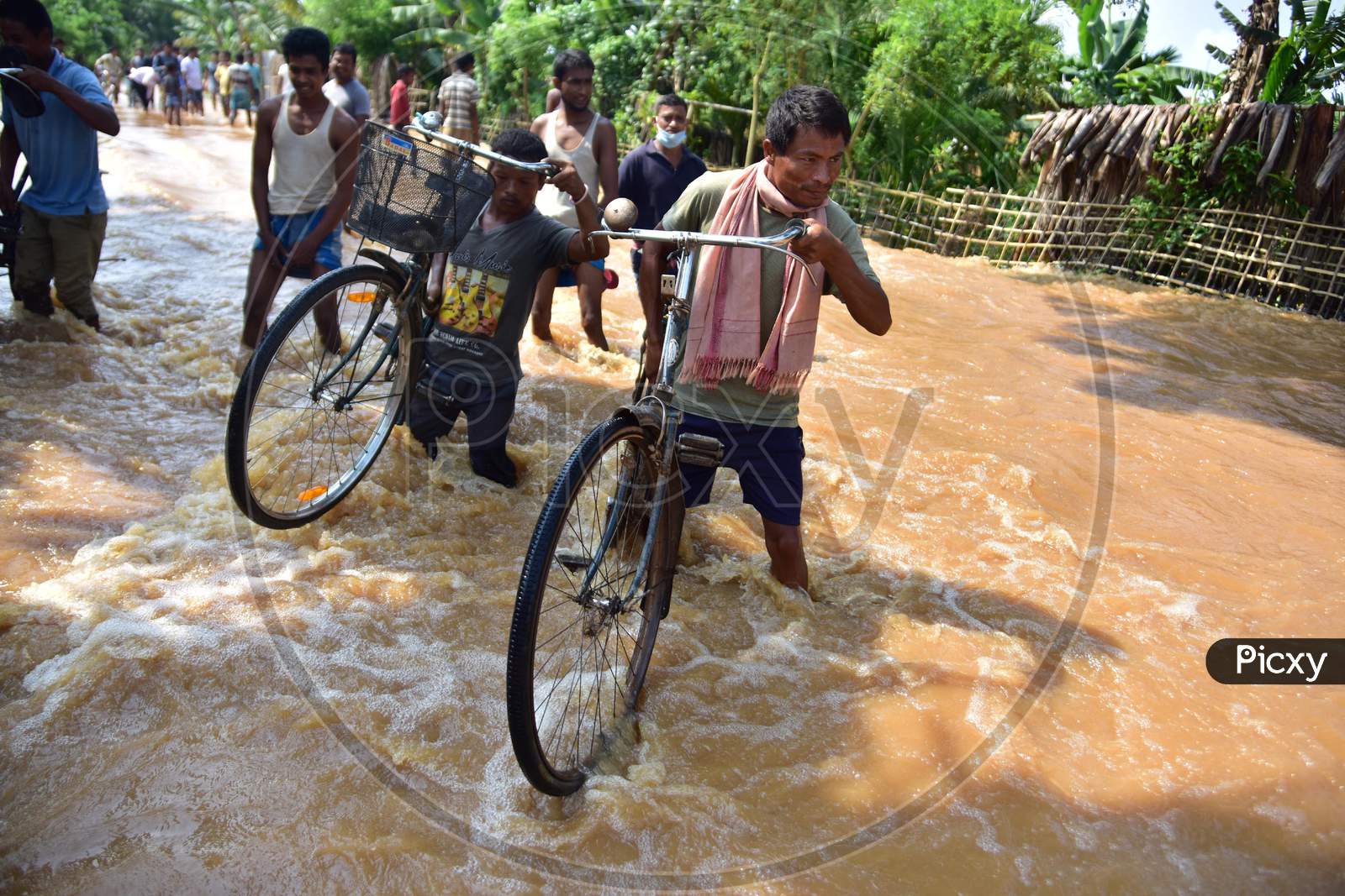 Villagers Carry Their Bicycle  As  They Wade Through Flooded Waters At  Pramila Village Near Kampur In Nagaon District Of Assam On June 7,2020