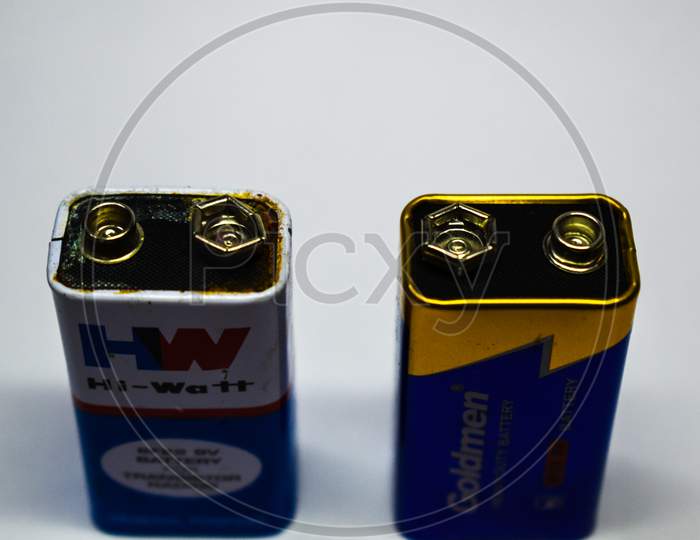 07/06/2020- Kerala,India: Close-Up Of An Old Leaked 9V Dry Cell Battery Of Hw Brand And A New 9V Dry Cell Battery Of Goldmen Brand On White Background. Selective Focus Applied.