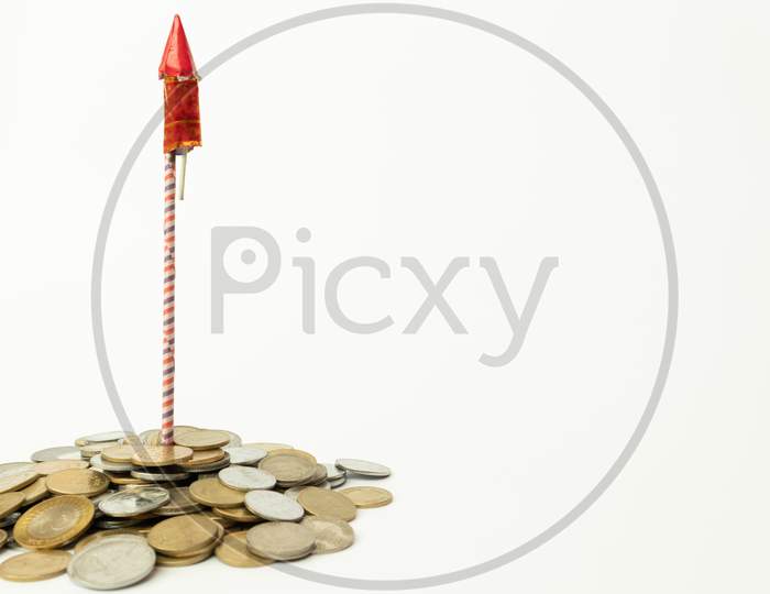 Firecracker Rocket On Stack Of Coins On Isolated Background With Copy Space.