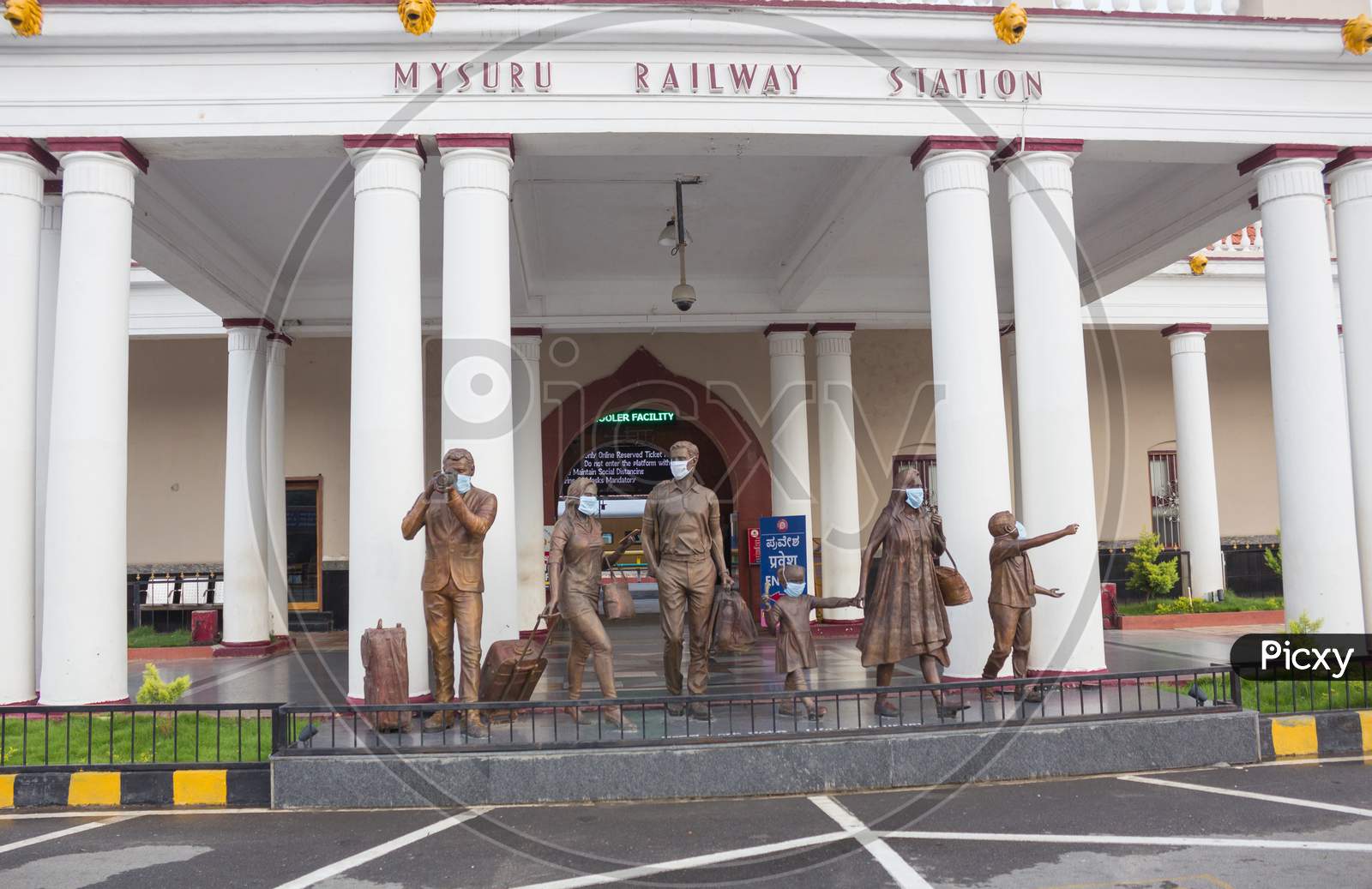 Mask wearing bronze sculptures at Mysore Railway Station