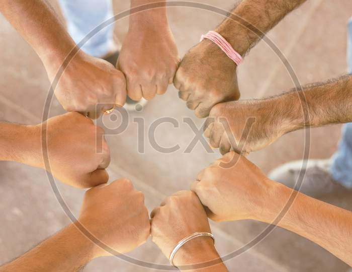 Close Up Top View Of Young People Doing Fist Bump By Hands Together