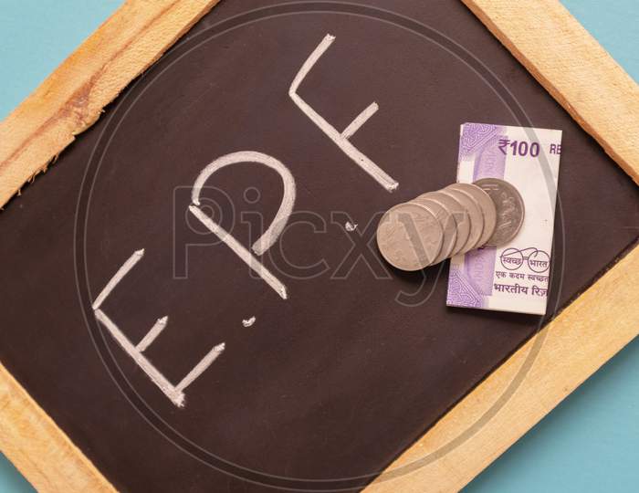 Epf Or Employee Provident Fund Written On Black Slate With Indian Currency Notes And Coin