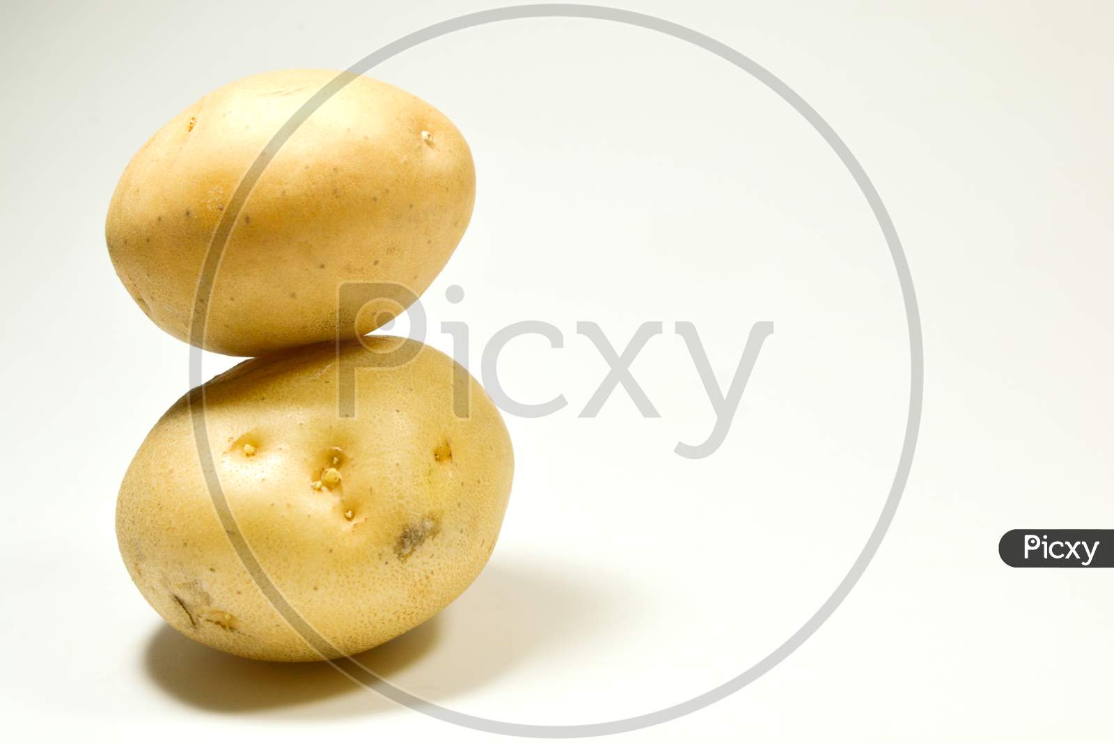 Two Fresh Potatoes Kept On One Above One Isolated On White Background