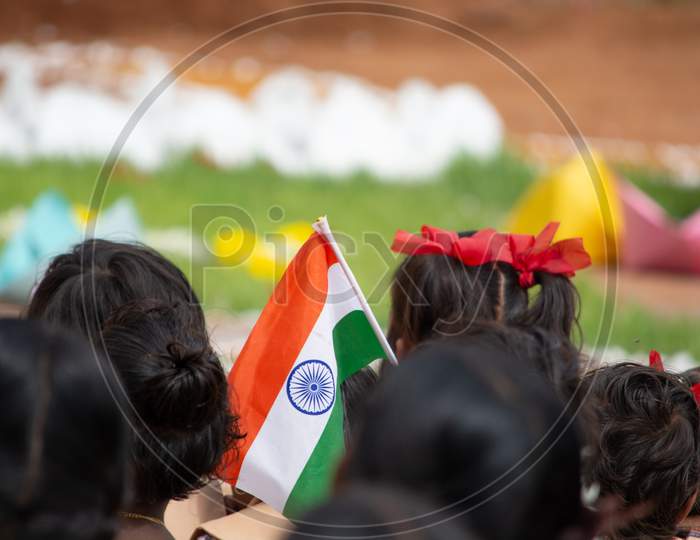 School Children Sat Ground By Holding Indian Flag In Hand During Independence Day Of India.