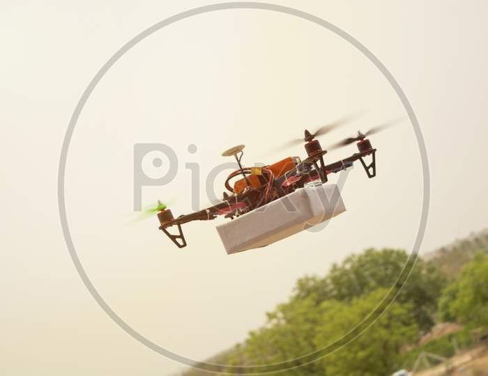 Concept Of Assembled Drone Quadcopter Delivering A Package