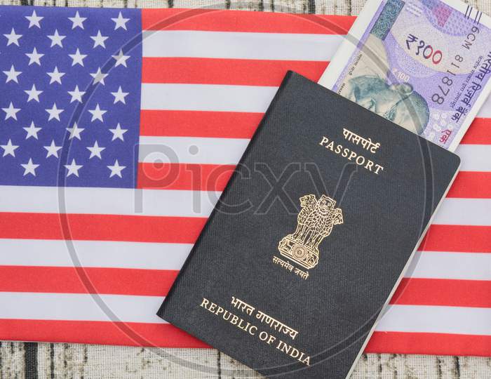 Indian Passport With Currency On Usa Or America'S Flag As A Background