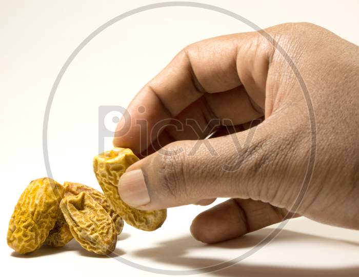 Dry Dates Picking With Hand Isolated On White Background