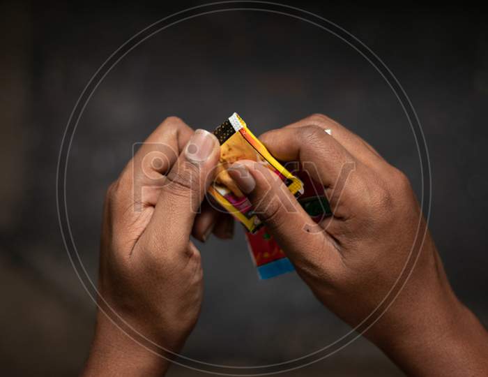 Close Up Of A Man Hand Tearing The Chewing Tobacco, Gutka Or Gutkha In India.