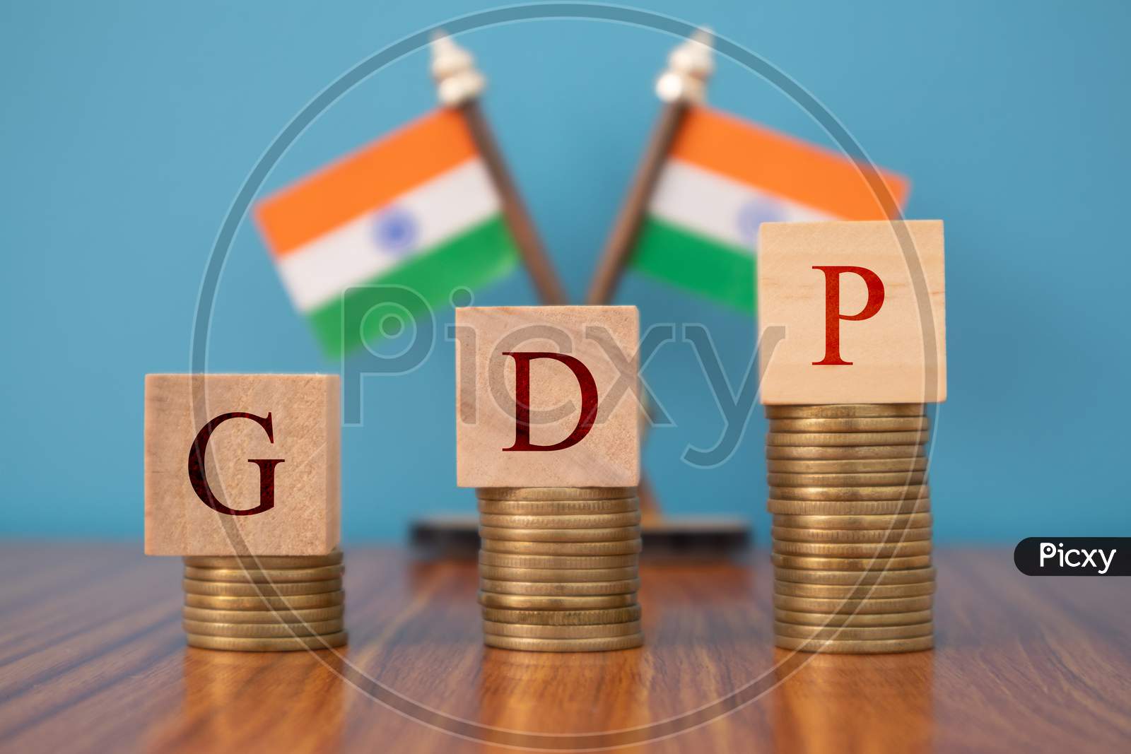 Gdp Or Gross Domestic Product In Wooden Block Letters On Coins In Increasing Order With Indian Flag As A Background.