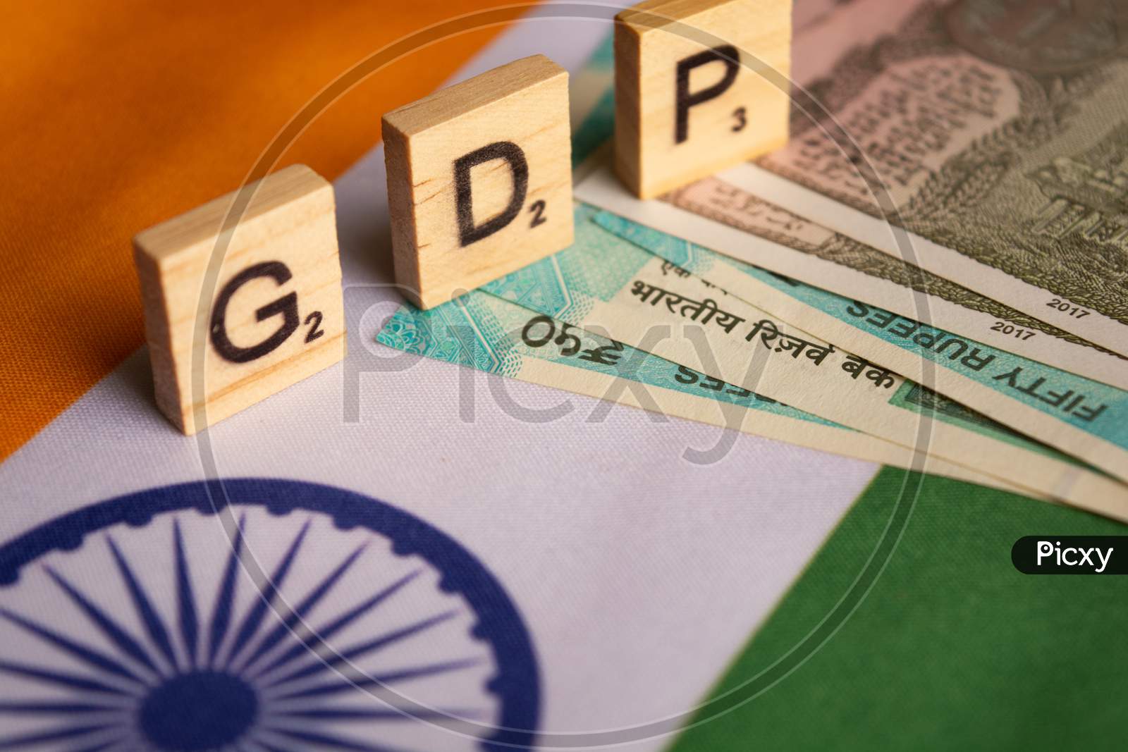 Gdp Or Gross Domestic Product In Wooden Block Letters On Indina Flag With Indian Currency
