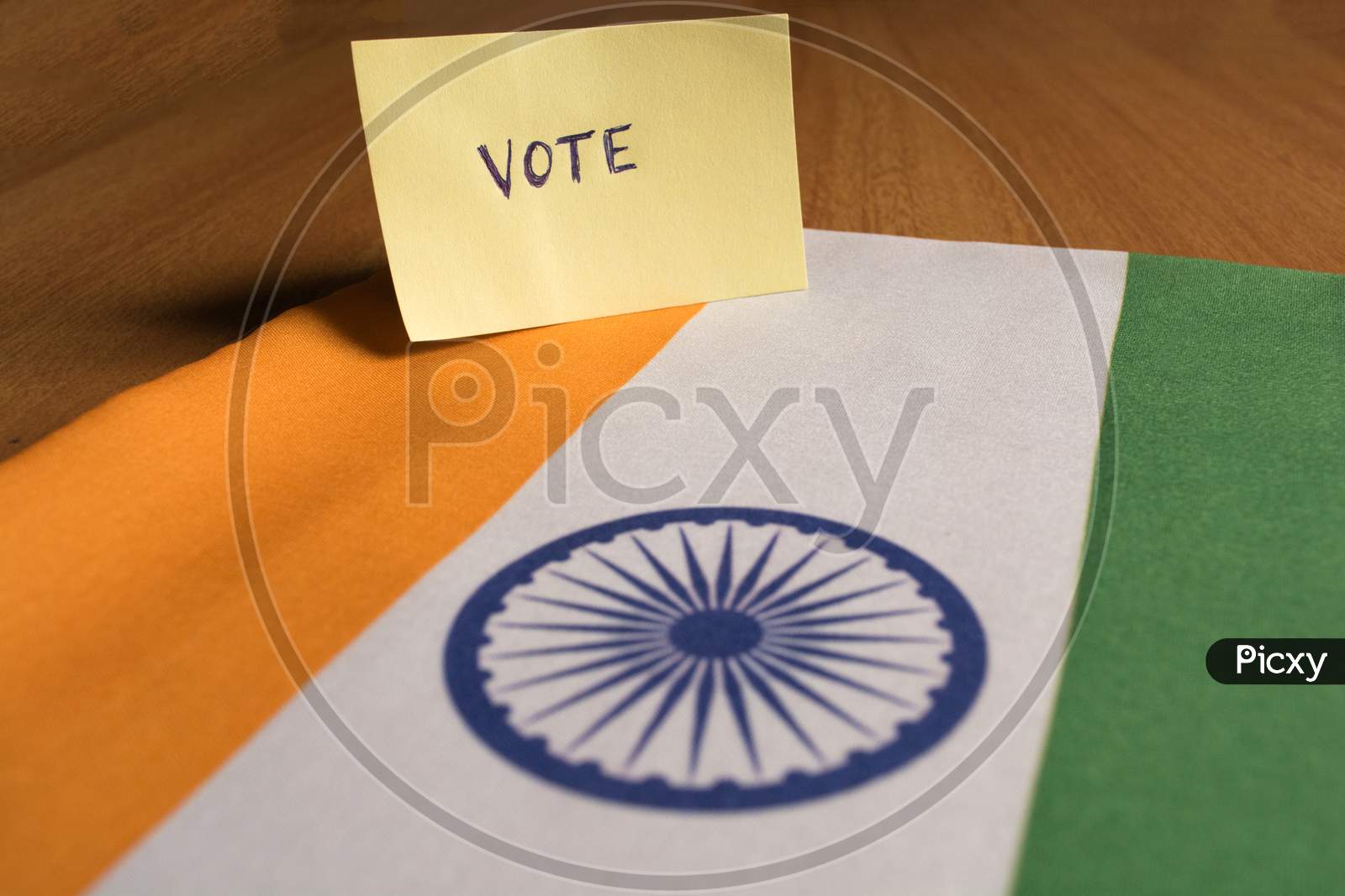 Voting Concept - Hand Written Voting Sticker On Indian Flag.