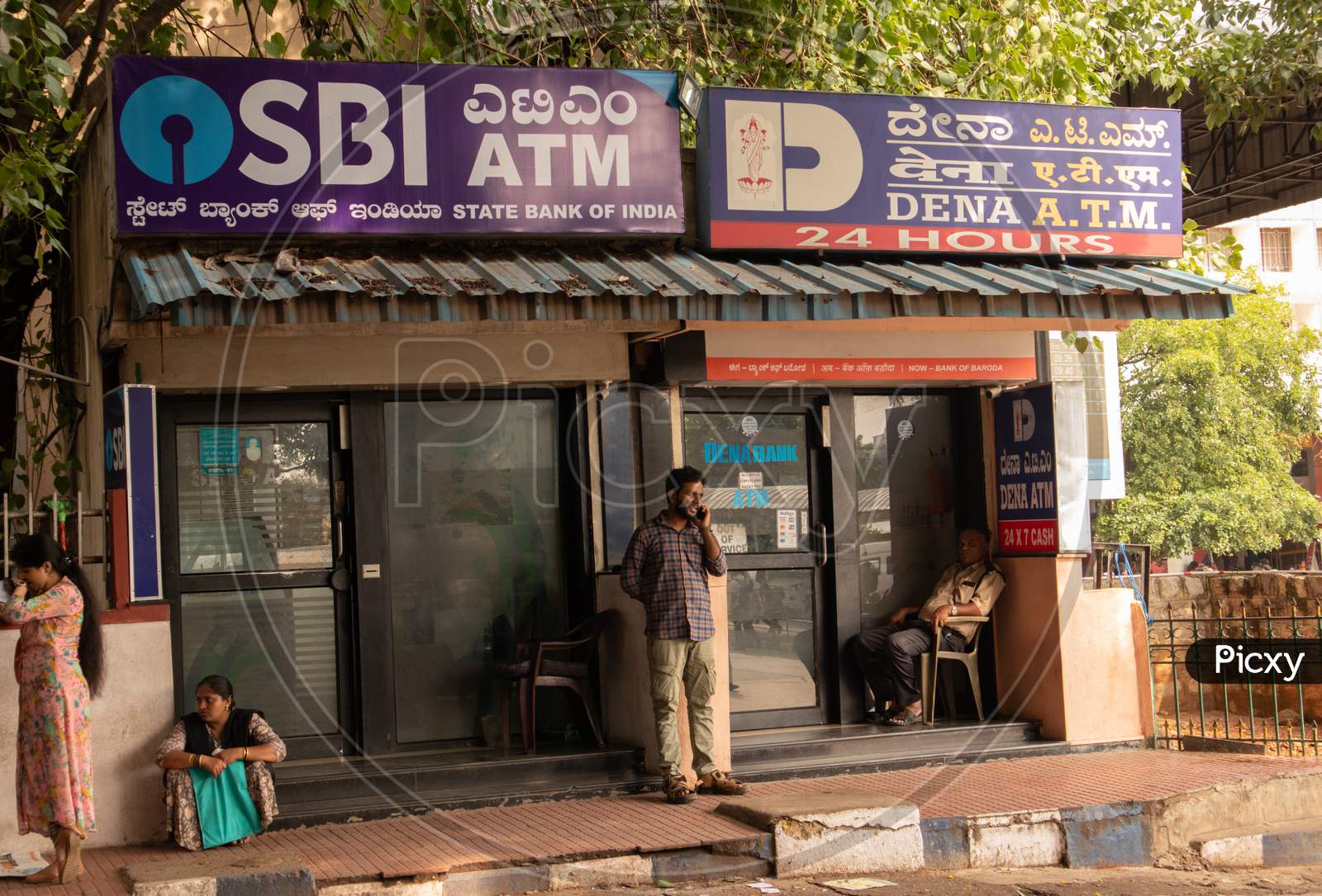 People Sitting Infront Of The Sbi Atm And Dena Bank Atm'S At Bangalore Railway Station.