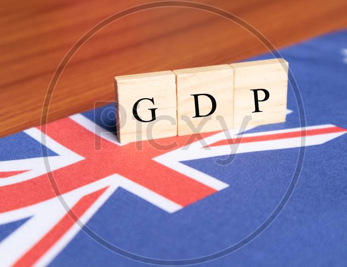 Gross Domestic Product Or Gdp Of Australia In Wooden Block Letters On Australian Flag.