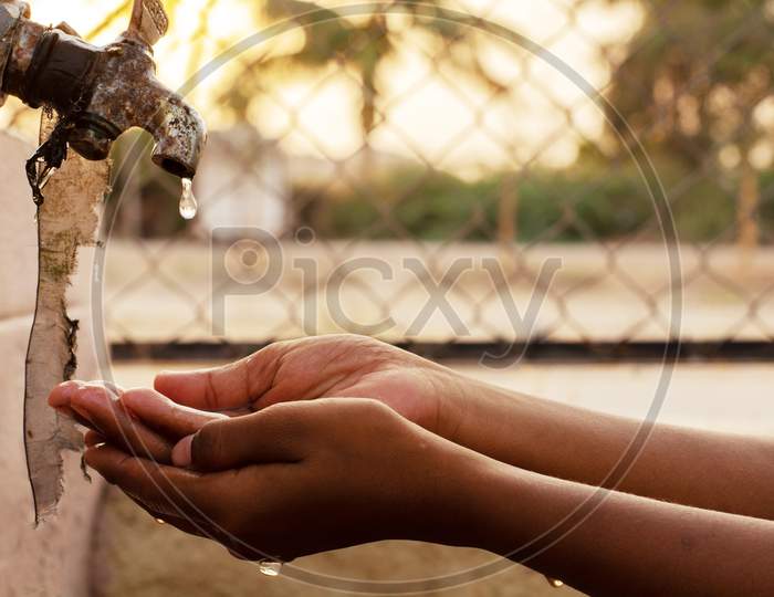 Closeup Of Hands, Child Drinking Water Directly From Corporation Tap Water In India