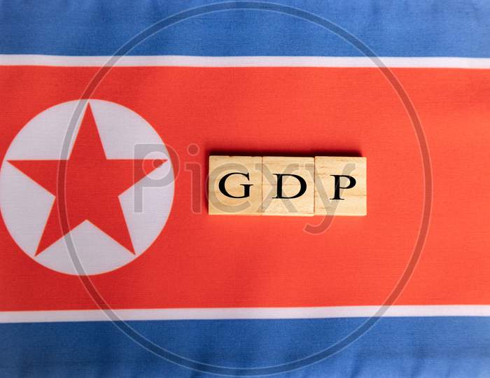 Gross Domestic Product Or Gdp Of North Korea In Wooden Block Letters On North Korean Flag.