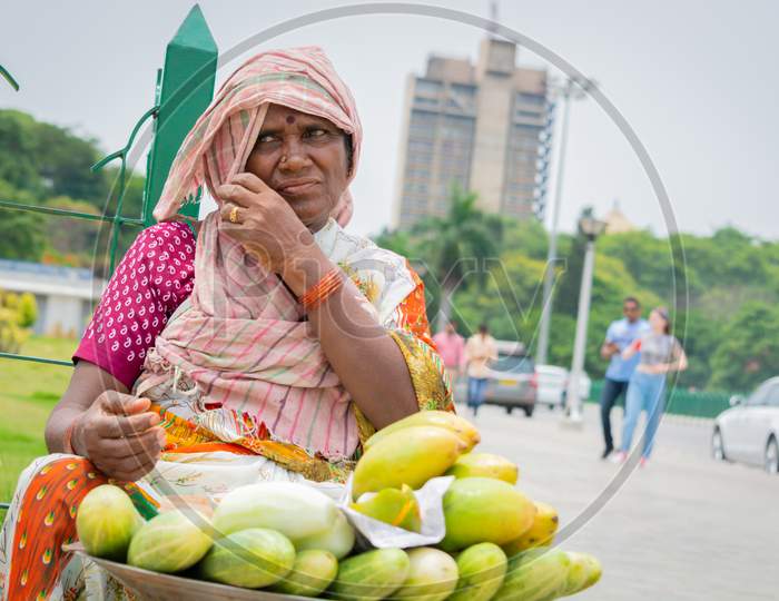 Bangalore, Karnataka India-June 04 2019 :Street Vendor Woman Selling Mango'S And Cucumber At Hot Sunny Day At Bangalore, India.