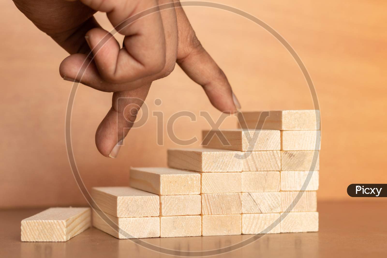 Hand Liken Business Person Jumping Directly From Bottom To Top Of The Wooden Toy Staircase On Wooden Textured Background