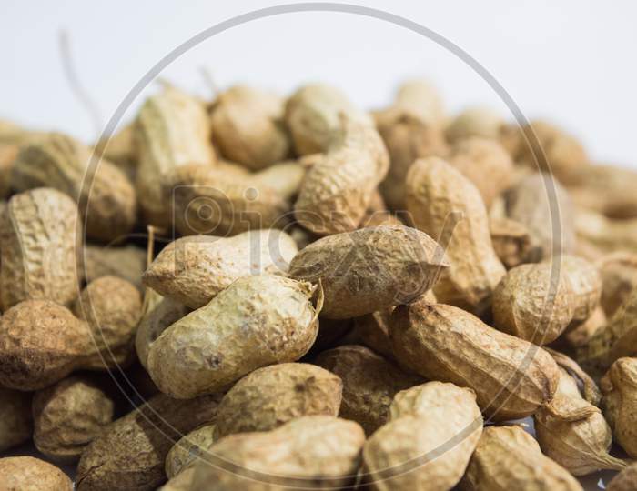 Close Up Of Peanuts Or Groundnuts With Wooden Spoon On Isolated Background