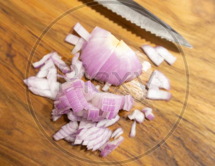 Close Up Chopped Red Onion On The Kitchen Cutting Board With Knife.