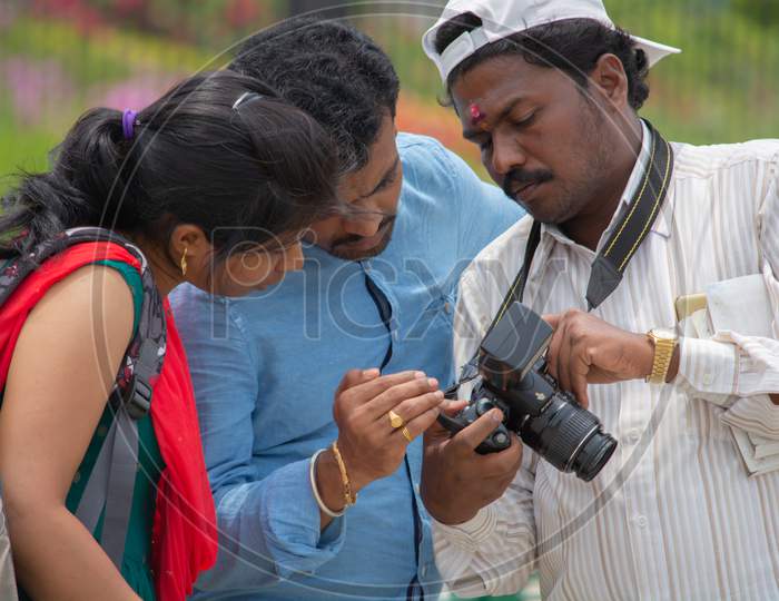 Bangalore, Karnataka India-June 04 2019 :Indian Photographer Showing Photos To Clients On Photo Camera Screen, Couple Looking At Image.