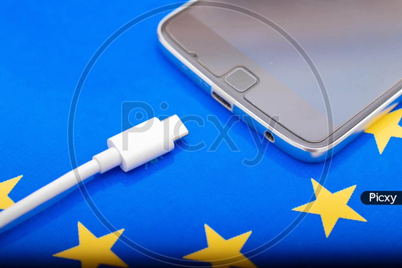 Close Up Mobile Phone Charger With Usb Type - C Cord On Eu Flag
