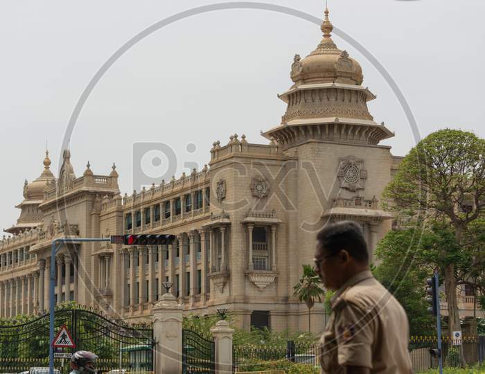 Bangalore, Karnataka India-June 04 2019 : Selective Focus On Vidhan Soudha And Traffic Signal With Karnataka Police Moving Infront Of Vidhana Soudha