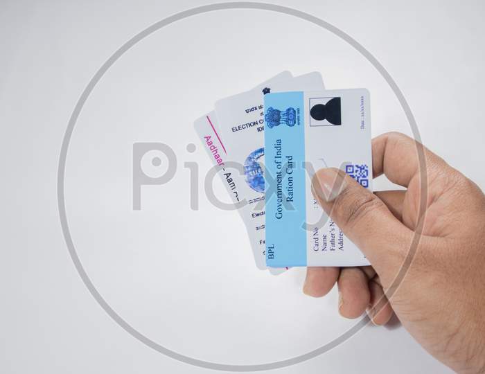 Holding Aadhaar Card, Ration Card And Voter Id Which Is Issued By Government Of India As An Identity Card On Isolated Background