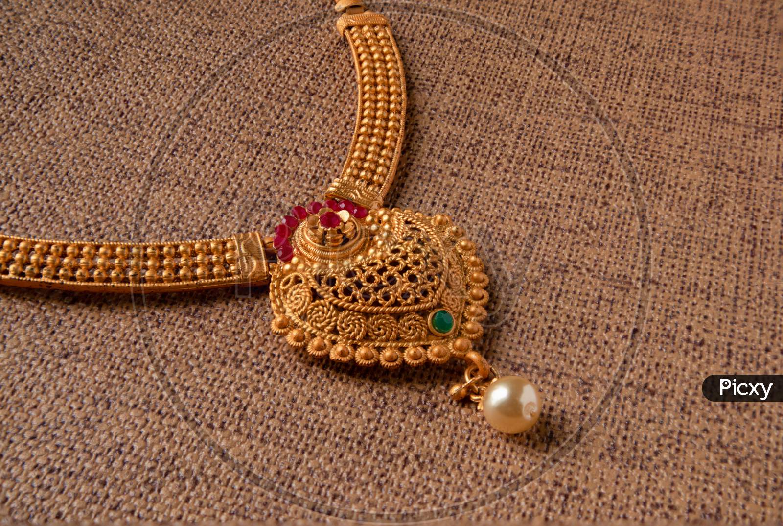 Indian Traditional Rolled Gold Or Gold Filled Necklace With Gemstones On Wooden Textured Background