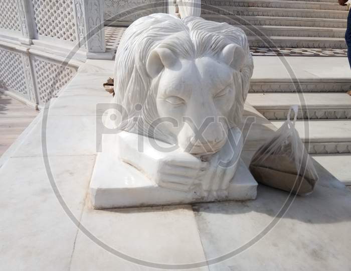 A statue of a sleeping lion on the main door of Karni Mata temple in Rajasthan