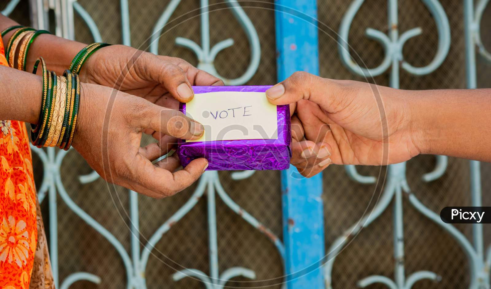 Person Giving Gift To Woman For Vote In Front Of The Door, Concept Of Showing A Gift For Vote.