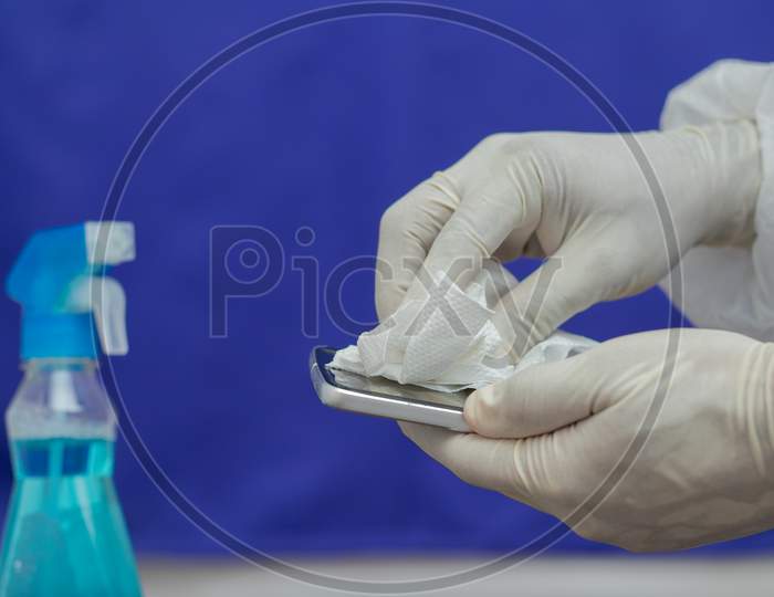 A Doctor Sanitising a Mobile Phone or Smartphone