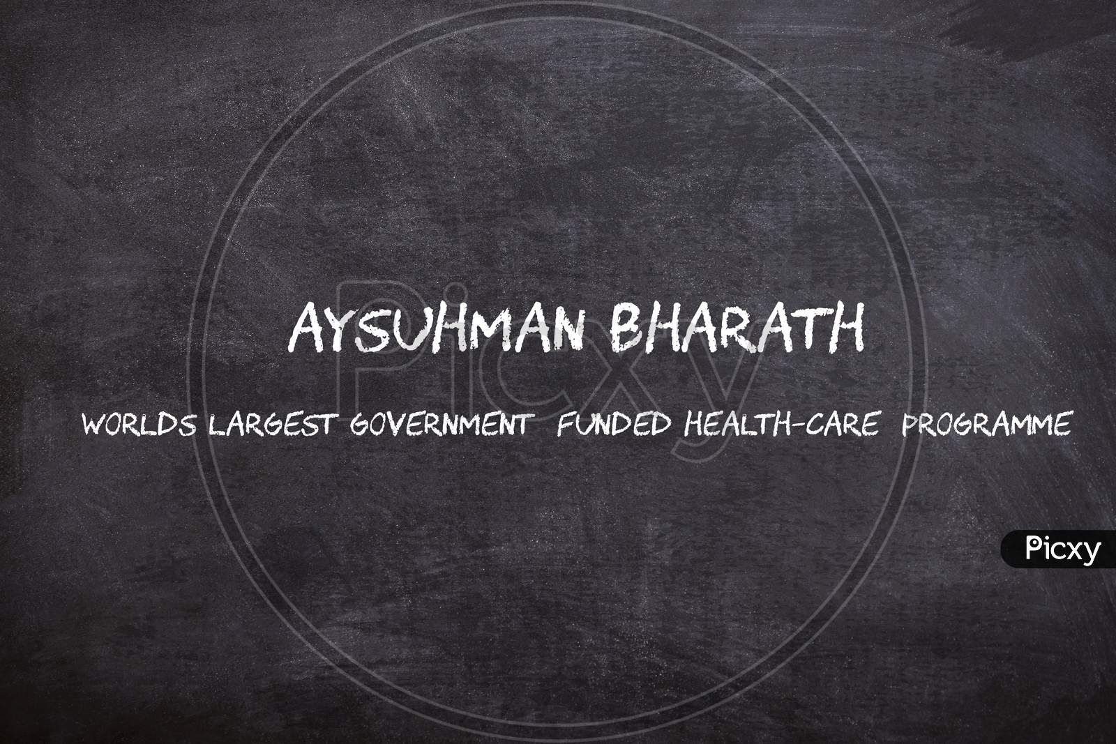 Ayushman Bharath written on a Black Chalk piece board