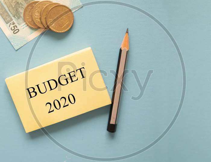 Concept Of Budget 2020 With Indian Currency Notes And Coins On Blue Background With Copy Space.