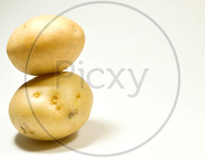 Two Fresh Potatoes Kept On One Above One Isolated On White Background