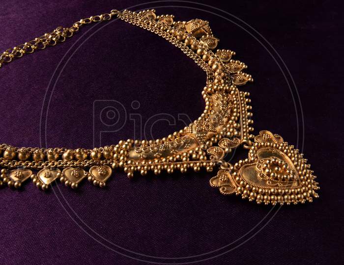 Gold Choker Necklace With Gemstones A Traditional Indian Wedding Jewelry On Blue Textile Backgroud