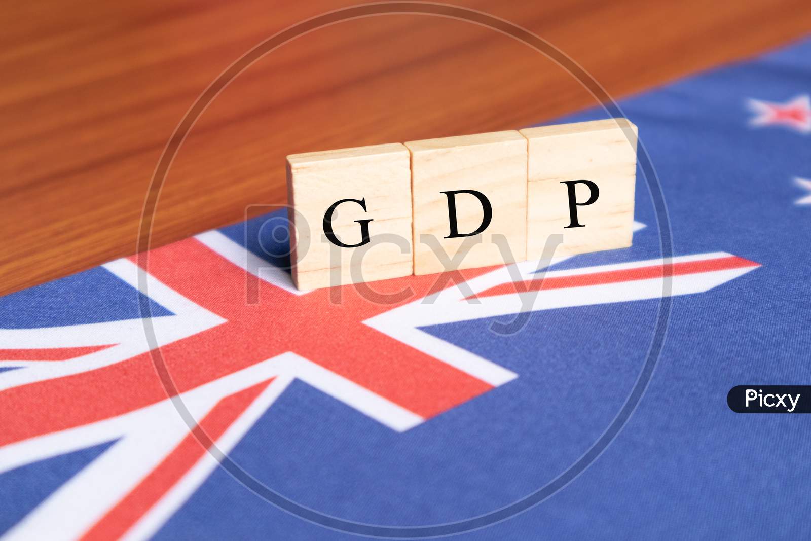 Gross Domestic Product Or Gdp Of Australia In Wooden Block Letters On Australian Flag.