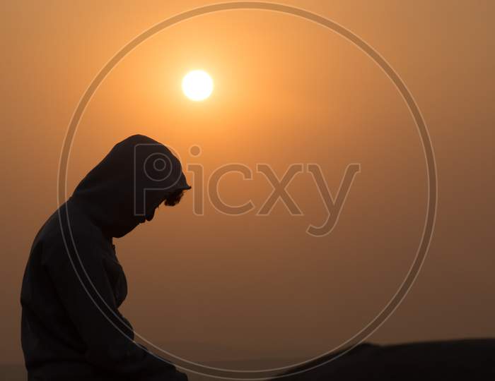 Silhouette Of A Young Man With Sun In Background