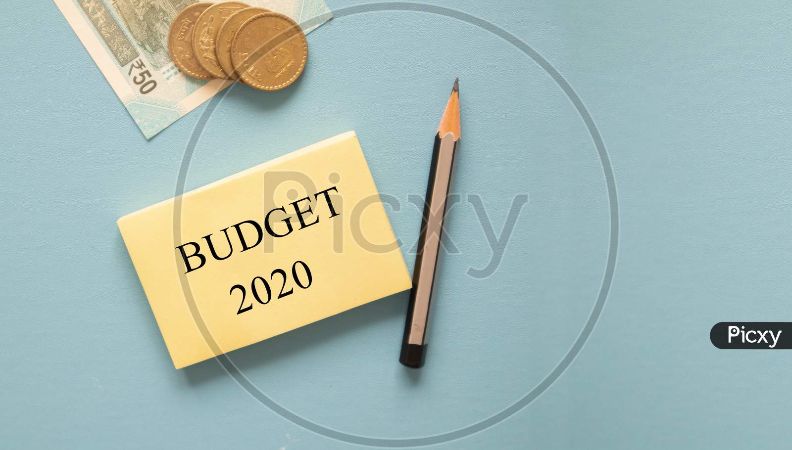 Concept Of Budget 2020 With Indian Currency Notes And Coins On Blue Background With Copy Space.