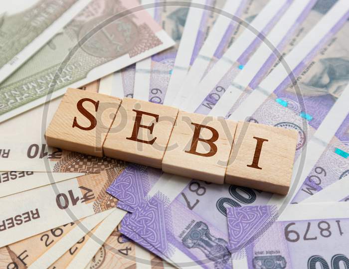 Sebi In Wooden Block Letters On Indian Currency.
