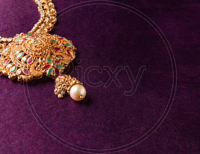 Gold Guttapusalu Necklace With Gemstones A Traditional Indian Wedding Jewelry On Blue Textile Backgroud