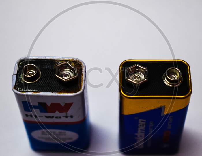 07/06/2020- Kerala,India: Close-Up Of An Old Leaked 9V Dry Cell Battery Of Hw Brand And A New 9V Dry Cell Battery Of Goldmen Brand On White Background. Selective Focus Applied.