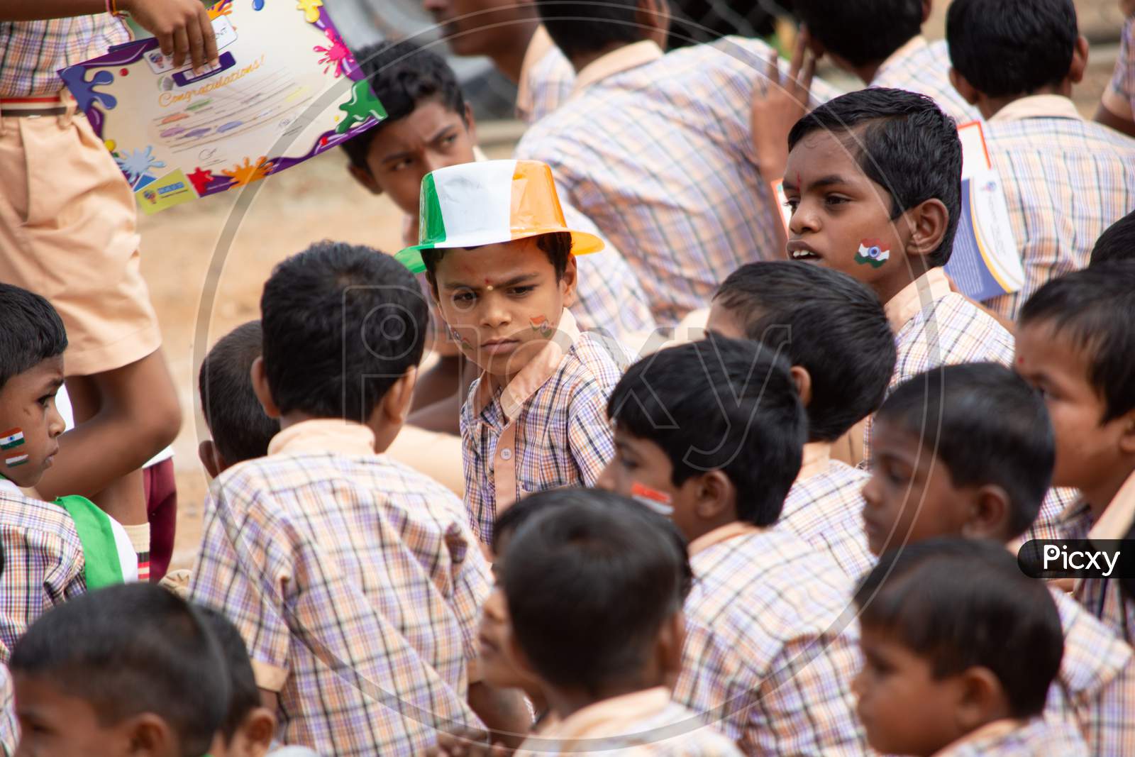A Group Of Elementary School Kids Sat On Ground During Independence Day Of India