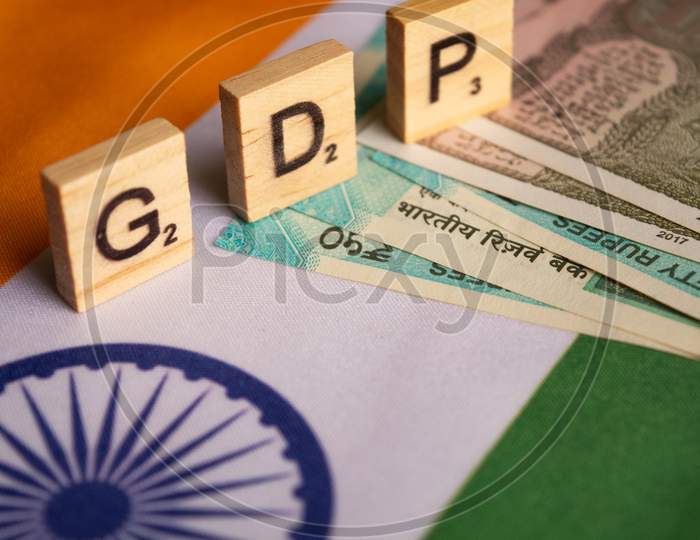 Gdp Or Gross Domestic Product In Wooden Block Letters On Indina Flag With Indian Currency