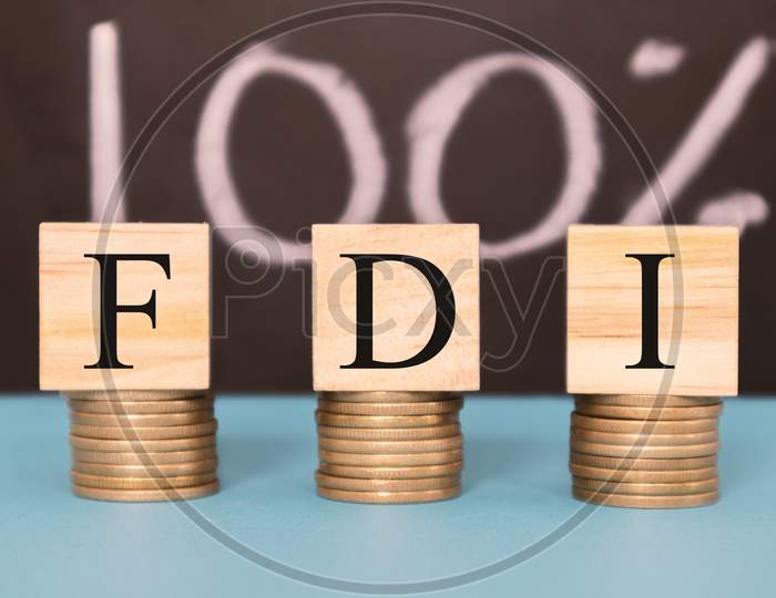 Finance Concept With Stack Of Coins - 100 Percent Fdi Or Foreign Direct Investment On Wooden Blocks.