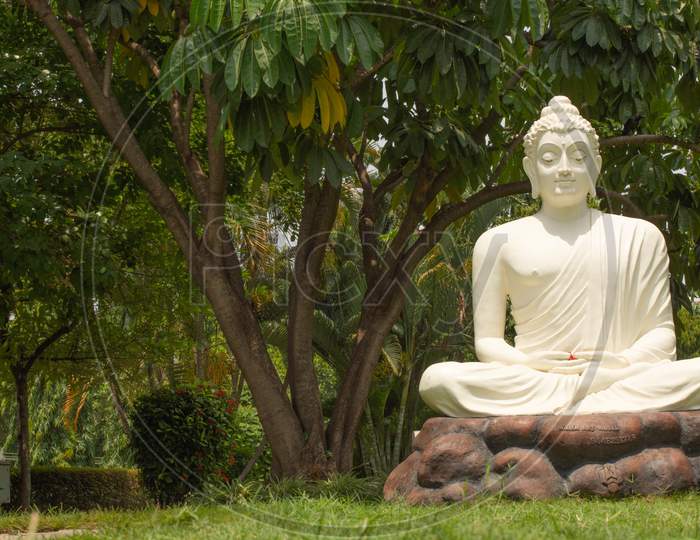 Bangalore, Karnataka India-June 04 2019 : White Buddha Statue In Meditating Posture On Stone Table With Nature As A Background