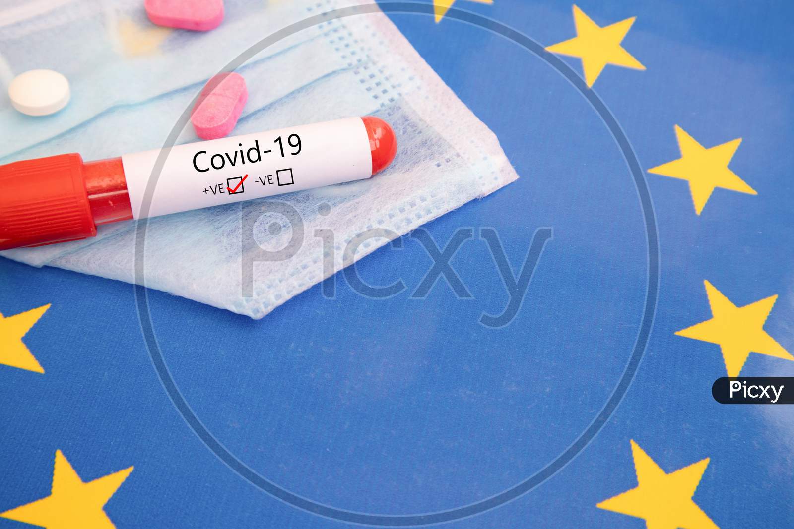 Concept Of Covid-19, Coronavirus Or Ncov 2019 Positive Test Found On Europe Showing With Blood Sample, Medical Mask, Tablets And Flag.