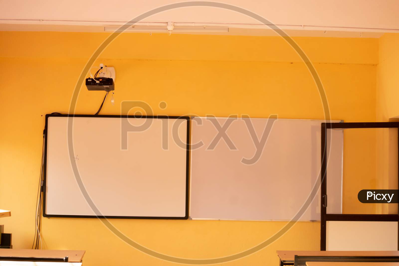 Classroom With Yellow Walls And White Boards With Projector.