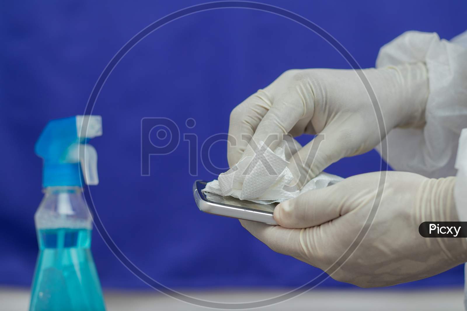 A Doctor Sanitising a Mobile Phone or Smartphone